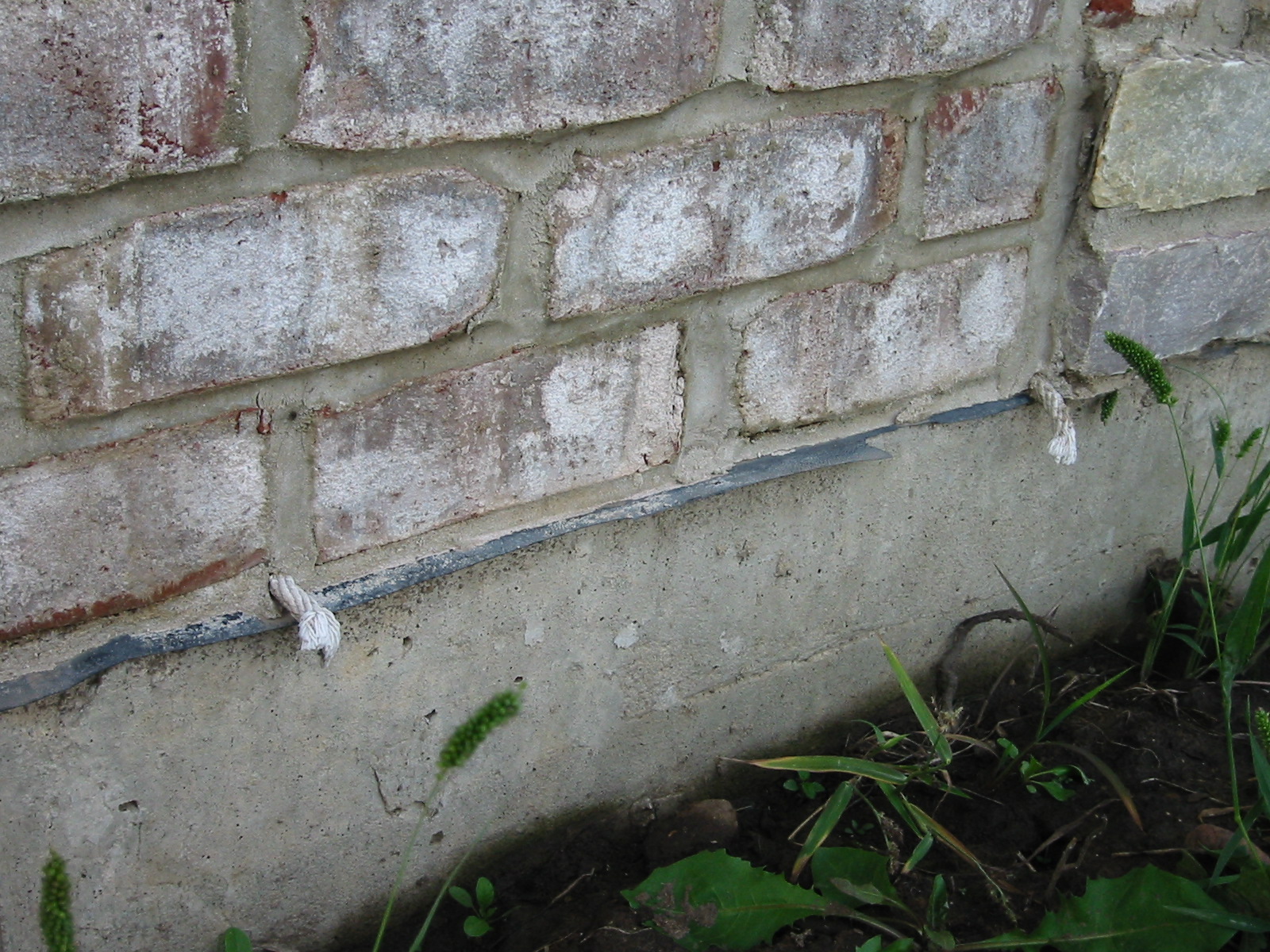 Weep holes: Rope inserted in the head joist between bricks will allow water to weep out of the base of the wall assembly.