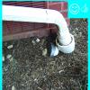 The downspout terminates into a catchment system that moves water away from the foundation of the house