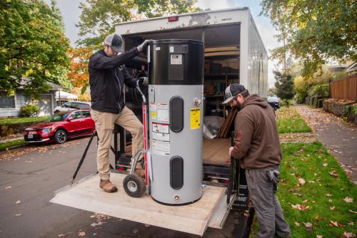Installers unloading a heat pump water heater