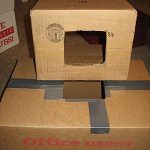 Cardboard boxes with cut holes, used for airflow measurements.