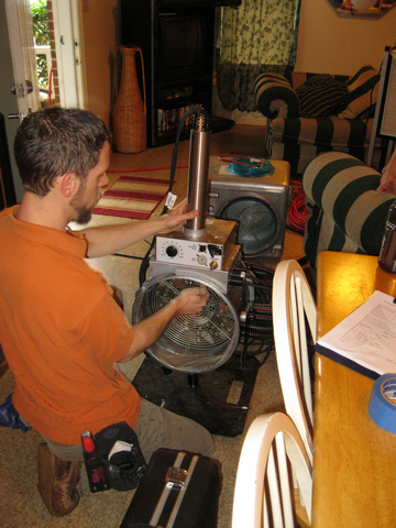 A technician assembles the spray sealant injection system to seal HVAC ducts from the inside.