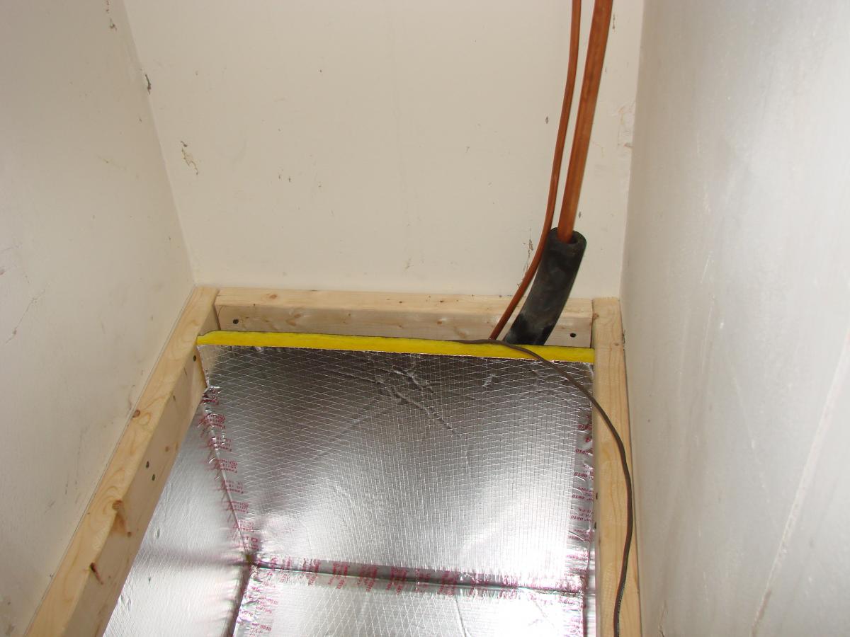 Foil-faced foam duct board is installed to line the sides and bottom of the return plenum in the air handler closet.