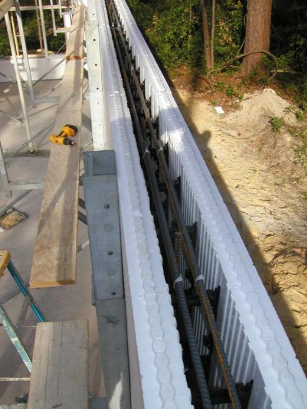 ICF bricks are stacked to form hollow walls that are reinforced with steel rebar before the concrete is poured in.