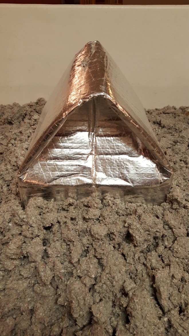 Attic insulation can come in contact with the recessed can light enclosure but should not cover the top of it.