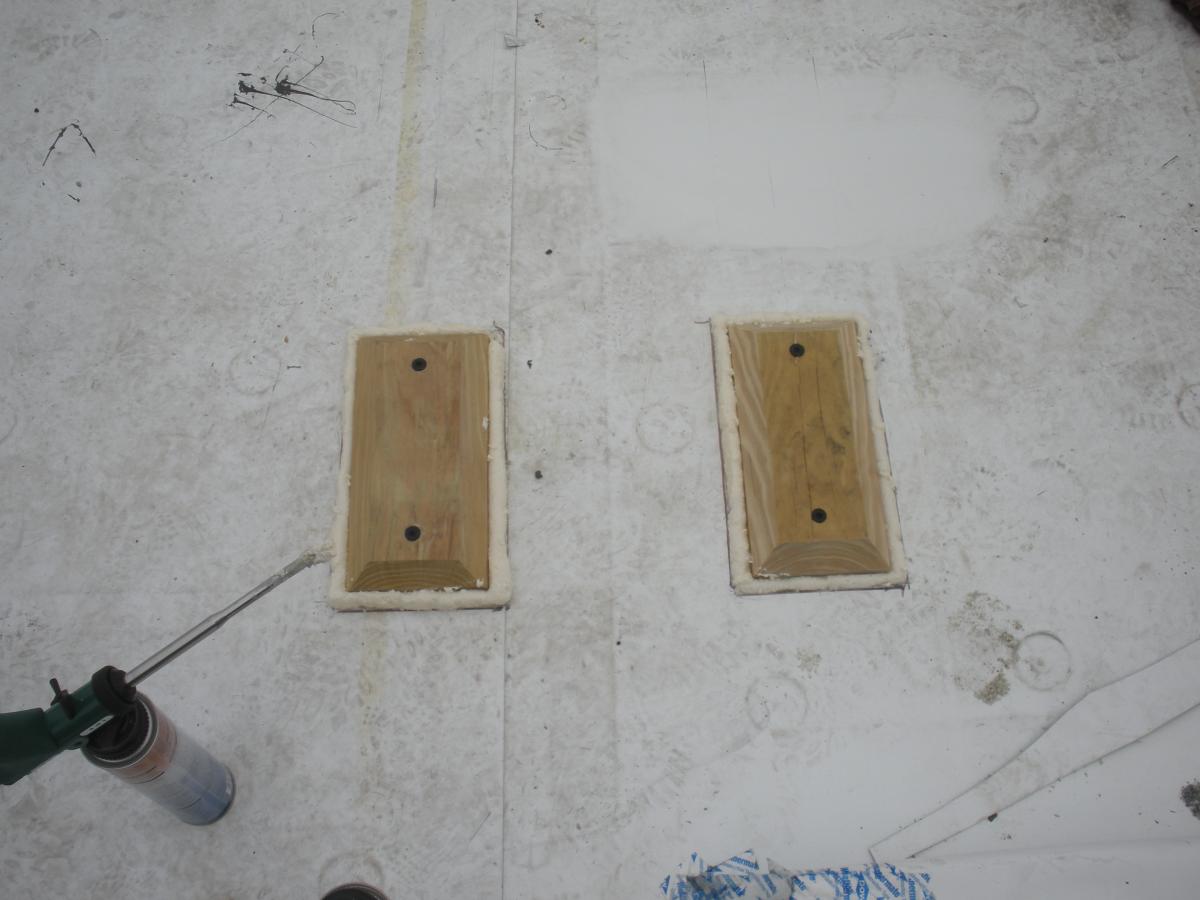 Blocking installed on a flat roof for a PV system rack is sealed around the edges with sealant then will be covered with self-adhering roof membrane to prevent water leakage.