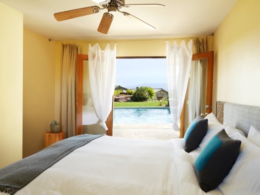 This room has several passive and low-energy cooling features including a ceiling fan, fully operable French doors, window shading, an outdoor water feature, and light-colored hard-scaping.