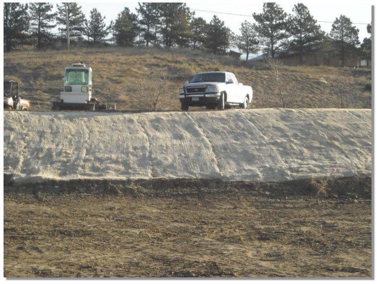 An erosion control blanket protects the slope from erosion and provides favorable conditions for bank revegetation.