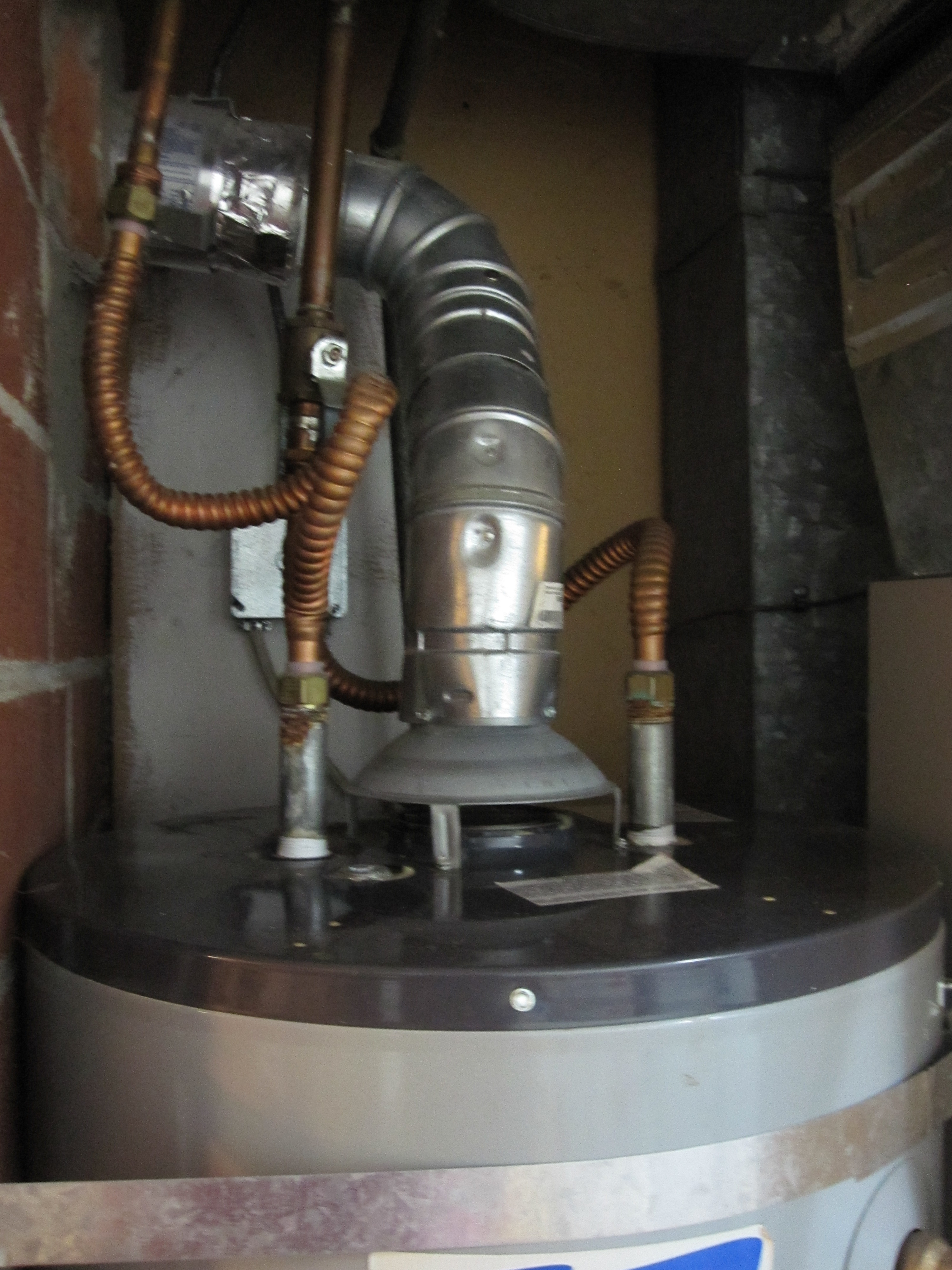 The raised hood at the base of the vent stack on this water heater shows that it is an atmospheric vented gas water heater.