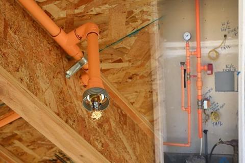 A roughed-in fire sprinkler head (left) and fire sprinkler riser (right) both use CPVC piping, a cost-effective choice for residential sprinkler systems.