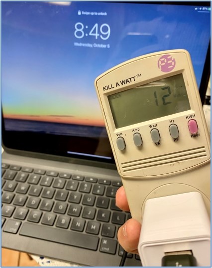 A portable power meter shows the power usage of equipment; e.g., this laptop is drawing 12 watts while idle
