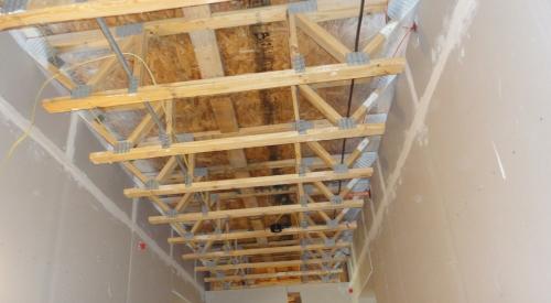 This air-sealing approach uses the wall drywall to isolate the corridor from the individual units in a multifamily building that has a truss floor structural system