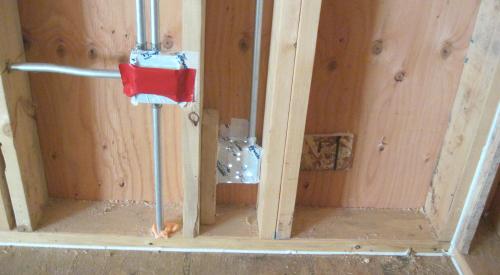 Right - Comprehensive air sealing of the walls includes caulking of the subfloor-sill plate seams and corner seams, taping of electrical boxes, and spray foaming around pipe penetrations.