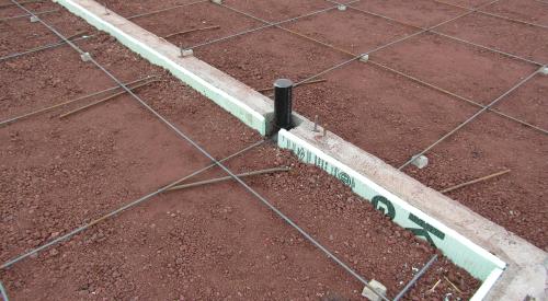 Two inches (R-10) of rigid foam line the interior of the perimeter footing walls before the post-tensioned slab is poured.