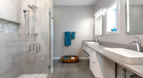 This bathroom is handicapped accessible with a zero-entry shower and roll-up sinks.