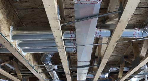 Right – The hard metal ducts are located in conditioned space between floor joists and all seams are sealed with approved metal tape.