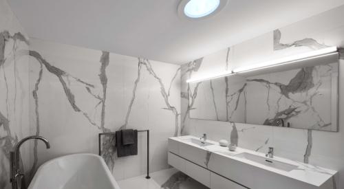 The solar tube installed in the ceiling of this bathroom brings natural light into an interior room that doesn’t have window access.