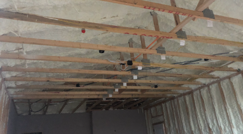 Right – The underside of this low-sloped roof is insulated with open-cell spray foam in this dry climate to achieve the code-required R-value; the builder used the same foam to insulate exterior walls. 