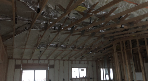 Right – Spray foam insulation is sprayed on the underside of the roof deck to provide a conditioned space in this low attic for the HVAC ducts.