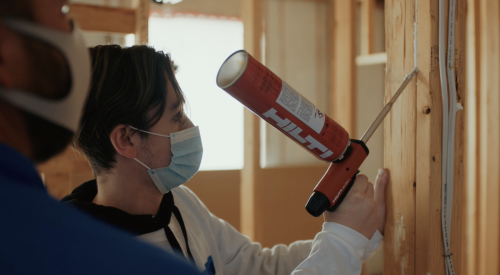 Right – A student uses a powered caulk gun to air seal wood-to-wood seams.