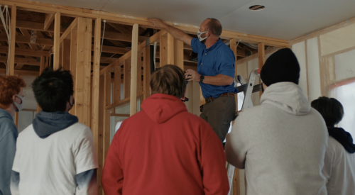 Right – An instructor shows students how to caulk the top plates of interior walls. 
