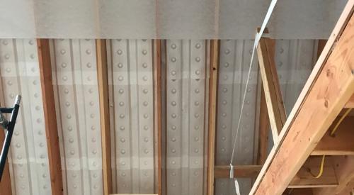 Right – Baffles are foamed in place between the roof joists of the vented, vaulted attic to direct air from the soffit vents up to the ridge vent.