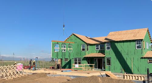 Right – This home’s above-grade walls are constructed in a factory where wall panels of 2x6 studs are assembled and sheathed with a coated OSB product, then windows are installed and flashed before shipping the panels to the site for assembly by crane. 