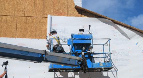 Right – House wrap is safely installed using a boom lift. 