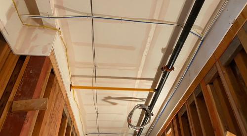 The ceiling and sides of this service corridor in a multifamily building are air-sealed with mudded and taped drywall prior to installing pipes, wiring, and ducts.