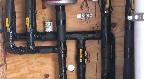 The home integrates roof-mounted solar hot water panels with an air-to-water heat pump; both sources feed into an 80-gallon stainless steel tank.