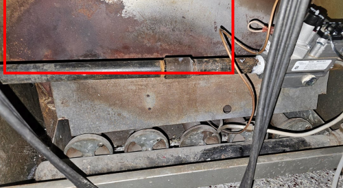 This furnace exhibits signs that it has backdrafted in the past, including soot marks on the sheet metal outside of the burner tubes.