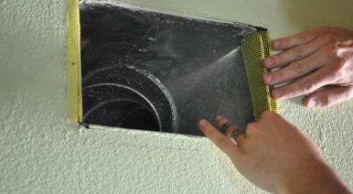 The gap between the duct boot and the drywall is air sealed by covering the seam with fiberglass mesh tape and mastic.