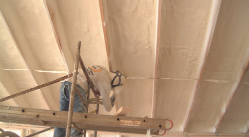 Right - A technician applies a thin layer of closed-cell foam to air-seal an unvented attic assembly before filling the ceiling joists with batt or blown insulation.