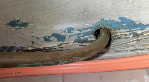 The gaps in the subfloor around this copper piping should be sealed with caulk or canned spray foam.