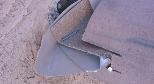 Improvised deflectors that are improperly integrated into the wall flashing and gutter are rarely sized to handle the volume of water that can run off the roof in a large downpour and they may contribute to water entry into the wall.