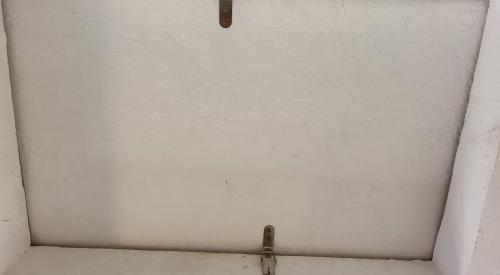 Latches were added to this attic access panel to hold it more tightly against the weatherstripping for better air sealing when closed.