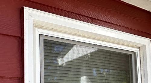 The metal head flashing over the window trim angles out slightly to provide a drip edge so rain water will drop away from the window instead of rolling down onto the window trim.