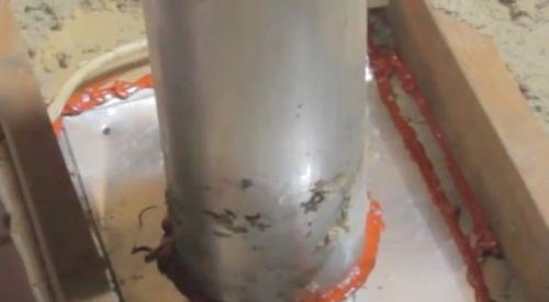 . Install sheet metal to cover the gaps around a flue pipe in the attic; attach with screws or heavy staples, then seal seams with fire-rated caulk or foam