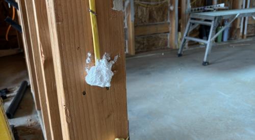 Right - The plumbing and wiring holes in this garage-to-house wall have been air sealed with spray foam