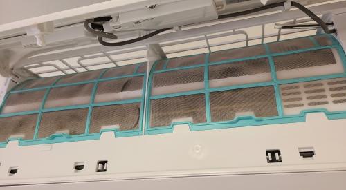 In this ductless heat pump model, the air filters are located behind the hinged front panel