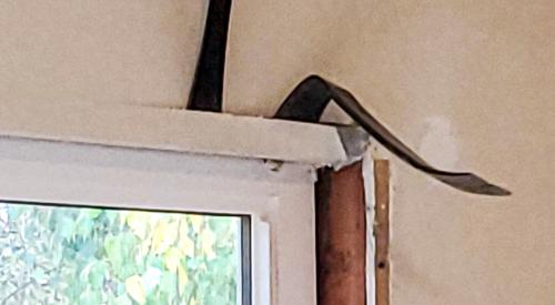 Use pry bars to remove the trim around an existing window to access the rough opening