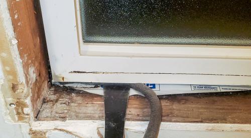 Use a pry bar or dull putty knife to push backer rod into the rough opening around an existing window