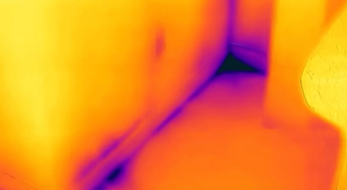 The dark areas in this IR camera image show air leakage coming up from the bottom plate along the wall. It is especially cold in the corner where the two exterior walls meet. 
