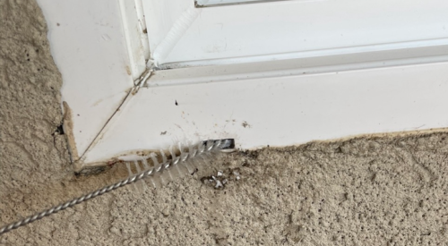 Push a straw cleaning brush or another thin brush back and forth into the window weep hole to clean out debris.