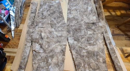 This is an example of an insulation pattern for rigid metal ducts that has been measured and cut in a comfortable location before being carried into the attic.