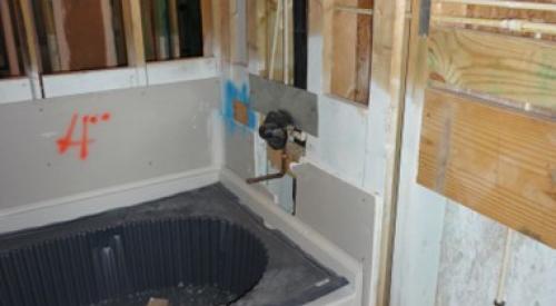 Gypsum board is installed behind the bathtub before the tub is installed and all seams are sealed