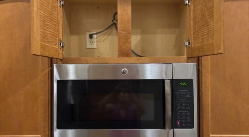 There is no duct visible in the cabinet above this microwave oven.