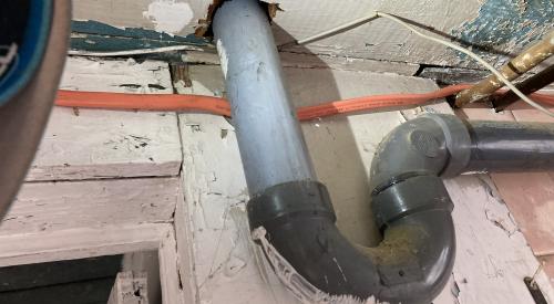 The large hole in the subfloor for this sink drain is a source of air leakage and should be sealed using canned spray foam.