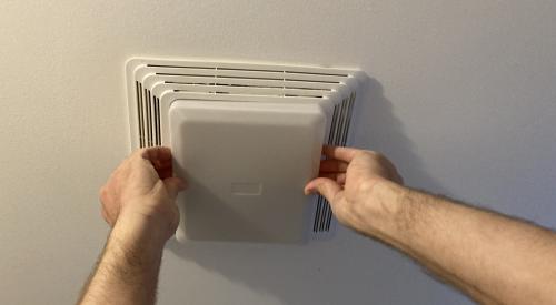 Press in on the sides of the plastic light cover to remove the light cover from the bathroom exhaust fan for cleaning