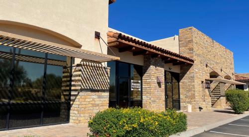 Right – this commercial building employs good techniques to resist solar heat gain:  awnings and pergolas over windows, recessed windows and entryways, deep tinting on glass, and shade plants.