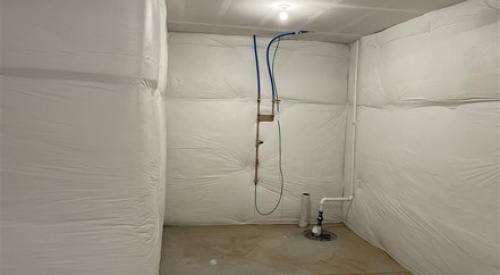 Right - The blanket fiberglass insulation is installed over a continuous layer of rigid foam insulation; the fiberglass is covered with a vapor retarder that is tape sealed at the seams.